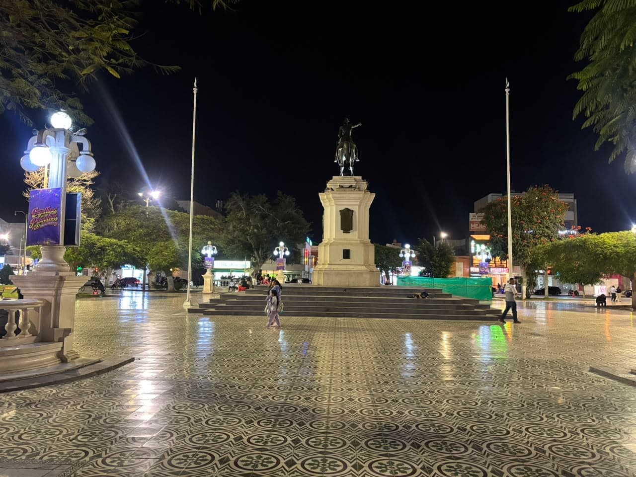 Plaza de Armas de Pisco, Perú, de noche, con el monumento ecuestre central